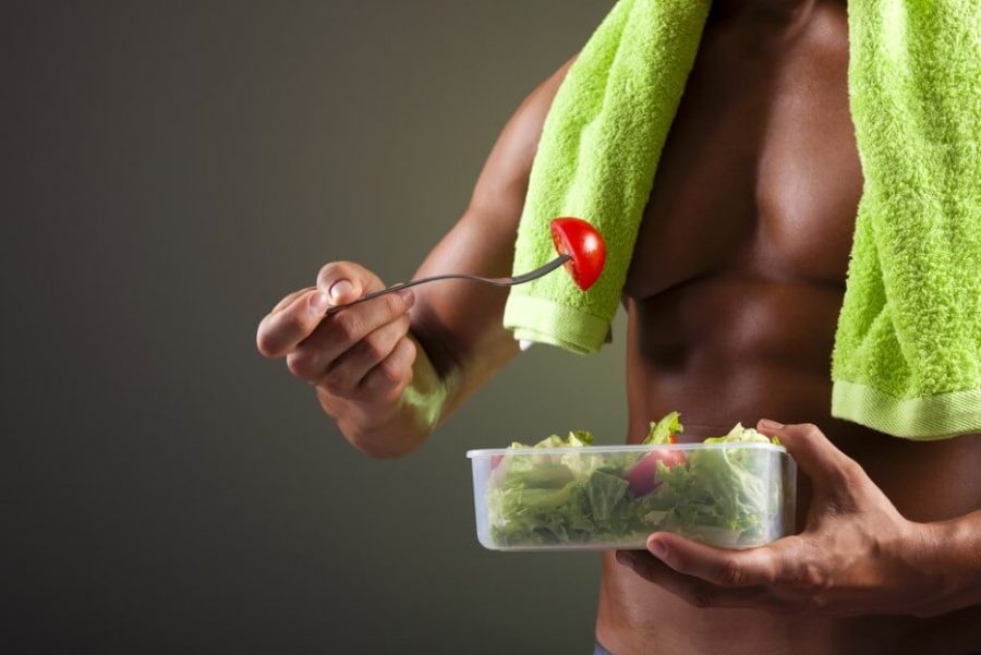 Strong man holding a bowl of fresh salad