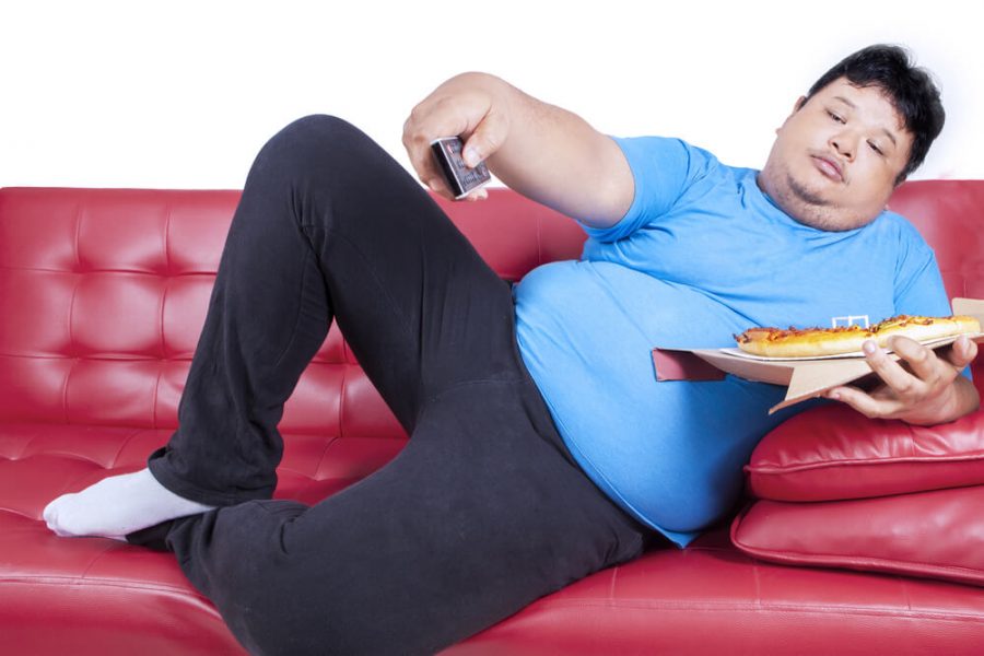 Overweight man eats pizza