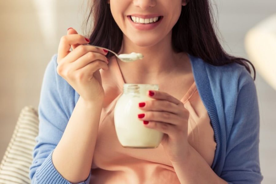 beautiful pregnant woman eating yogurt