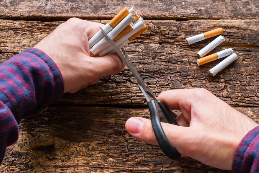 man cuts a cigarette with scisso