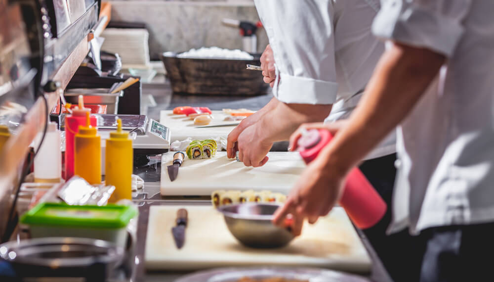 male cooks preparing sushi